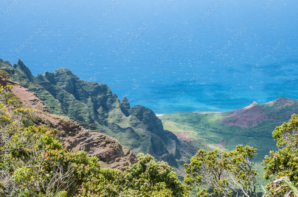 NaPali Coast of Kauai, Hawaii has mountains which descend into the Pacific Ocean. NaPali Coast of Kauai, Hawaii has mountains which descend into the Pacific Ocean.