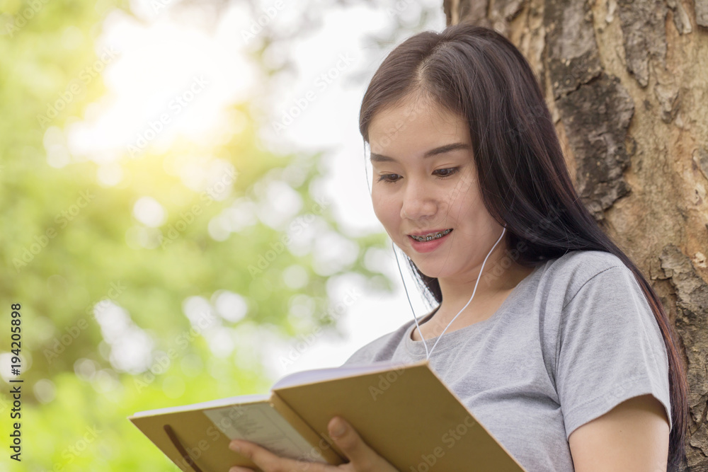 Beautiful Asian young woman relaxing with music in park Beautiful Asian young woman relaxing with music in park
