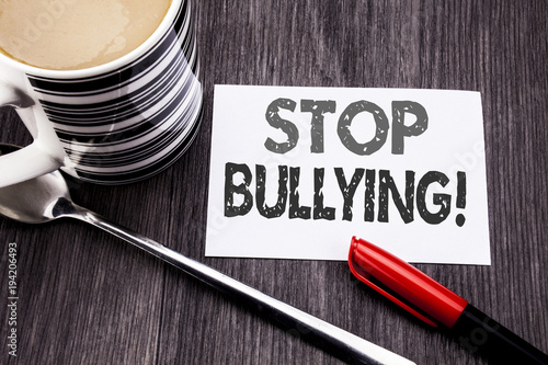 Conceptual hand writing text caption showing Stop Bullying. Business concept for Prevention Problem Bully written on sticky note paper on the wooden wood background. With coffee and marker photo