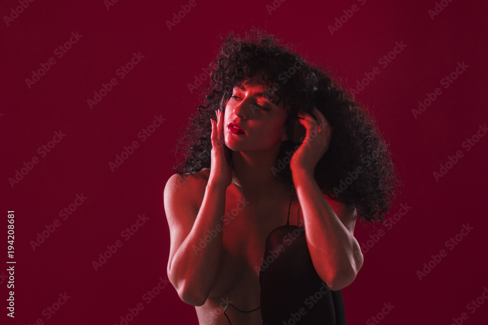 Topless curly woman with headphones in studio Topless curly woman with headphones in studio