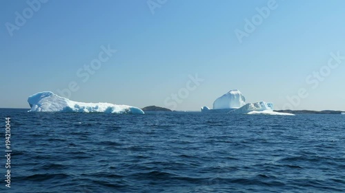 Beautiful large icebergs float in arctic blue water at twillingate photo