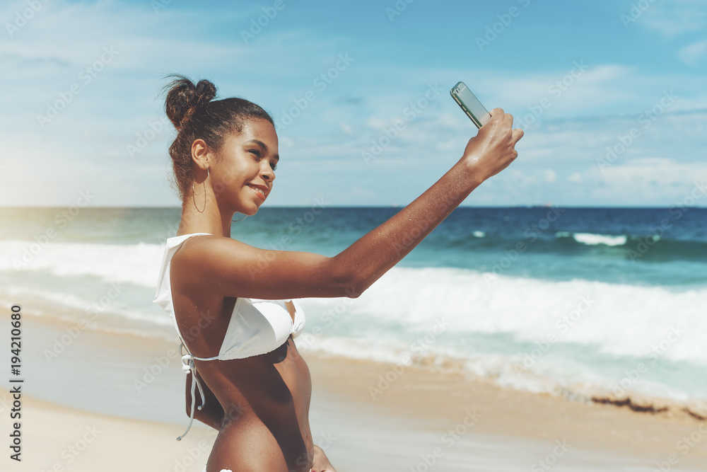 1000px x 667px - Young sexy Brazilian model girl is taking selfie while standing on the  ocean beach after swimming; beautiful and svelte African American female is  photographing herself on the seaside using smartphone Stock Photo |