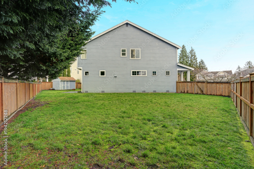 Obraz premium Fully fenced back yard with lots of space and a shed.