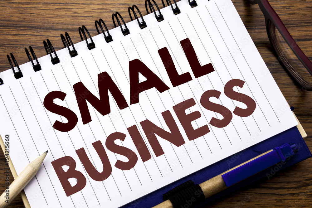 Fototapeta premium Hand writing text caption inspiration showing Small Business. Business concept for Strategy Management Written on notebook note paper, wooden background with glasses pen and marker.