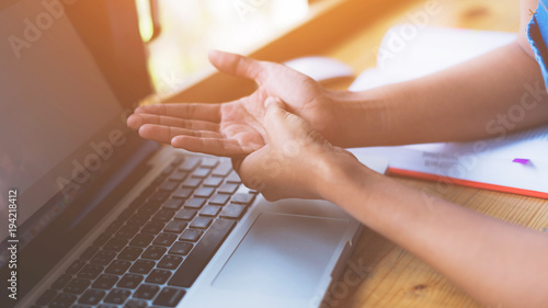 Wallpaper Mural Young woman is getting Hand pain caused at office desk in front of laptop,Office syndrome; Healthy concept. Torontodigital.ca
