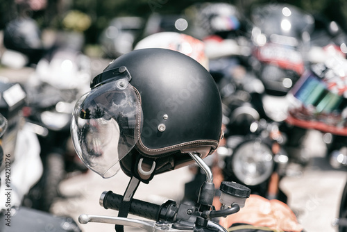 Vintage motorcycle helmet hanged on motorcycle in selective focus. © ichz
