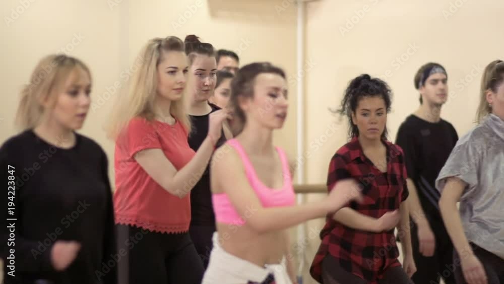 Young caucasian and hispanic people are dancing in the light studio Young caucasian and hispanic people are dancing in the light studio