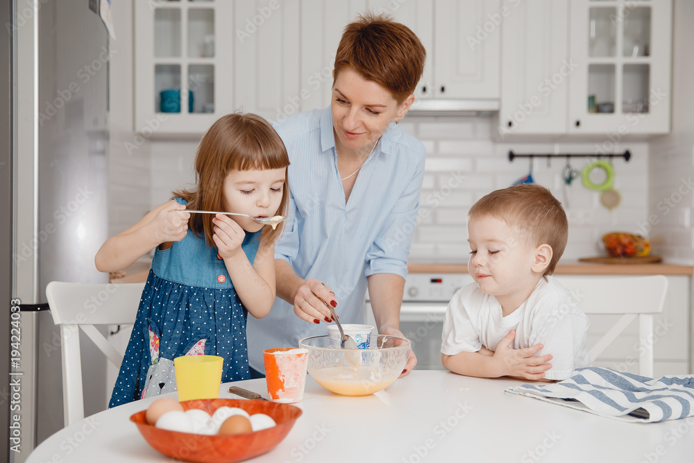 Children with their mother try cooked breakfast porridge. Concept healthy food. Children with their mother try cooked breakfast porridge. Concept healthy food.