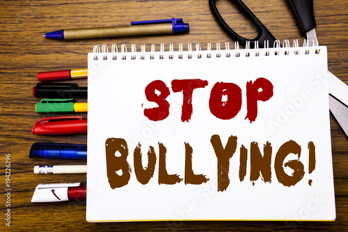 Word, writing Stop Bullying. Business concept for Prevention Problem Bully Written on notebook, wooden background with office equipment like pens scissors colourful marker photo