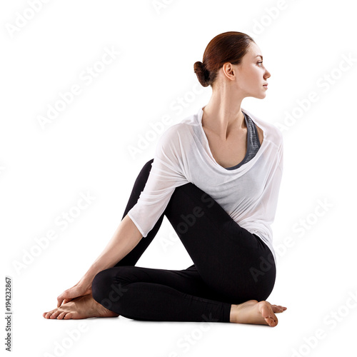 Young woman sitting on the floor and stretching.