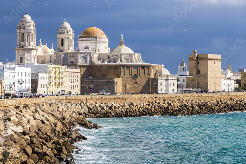 Views of Cádiz Cathedral (Catedral de Santa Cruz) from afar, with the coastline and the quay. Andalusia, Spain