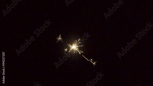 Firework sparkler burning on black background in slow motion
