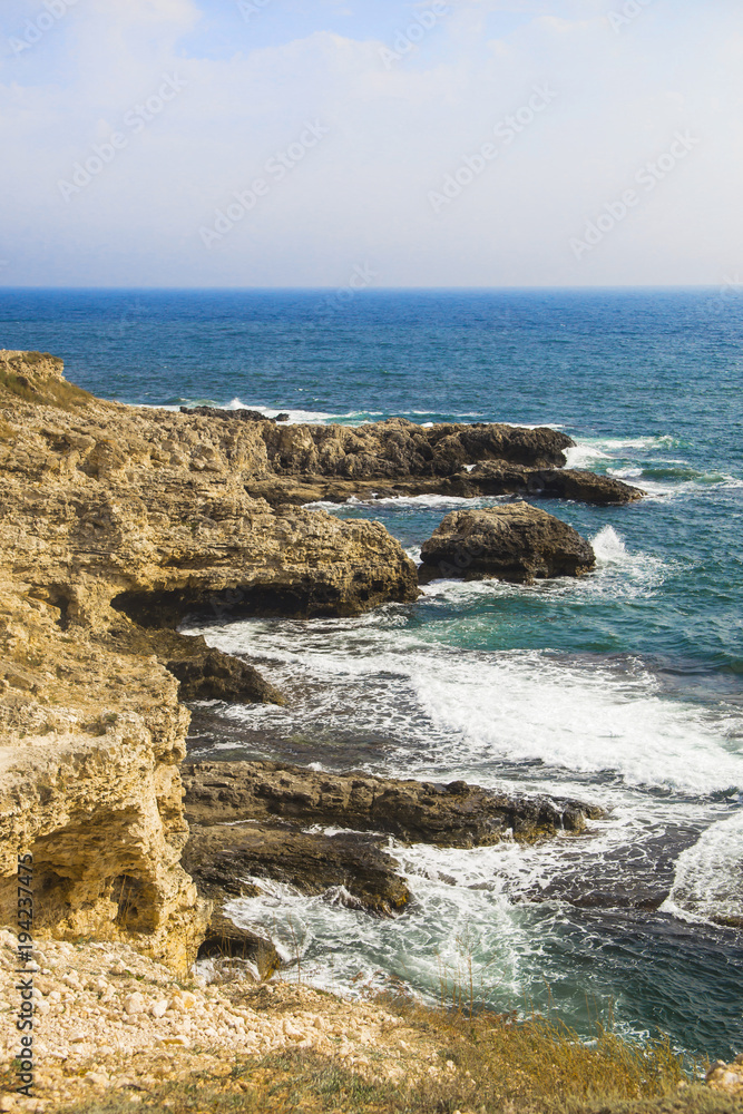 The sea landscape of Cape Tarkhankut, Crimea peninsula. Blue water and yellow rocks. Bright sunny background or wallpaper The sea landscape of Cape Tarkhankut, Crimea peninsula. Blue water and yellow rocks. Bright sunny background or wallpaper