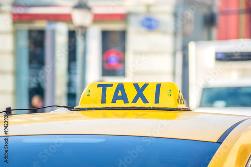 Yellow taxi sign. Taxi car on the street