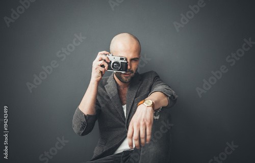 A bald man taking photos indoors enjoying