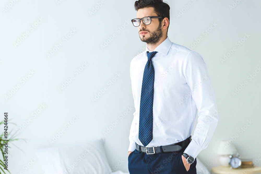 handsome businessman in white shirt and tie standing in bedroom - obrazy, fototapety, plakaty 