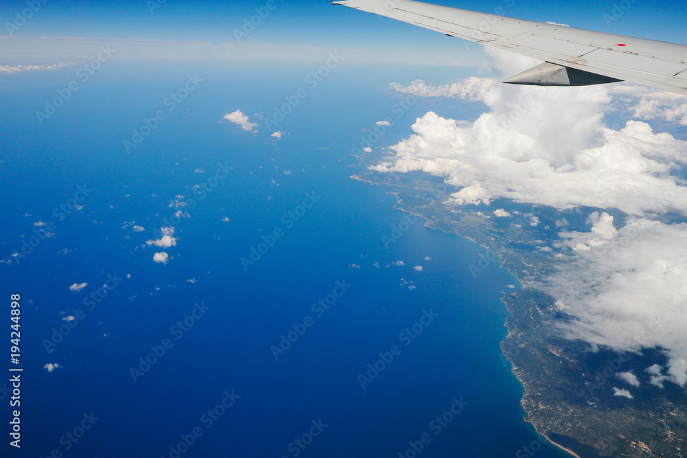 Blue sky and clouds below from airplane window Blue sky and clouds below from airplane window