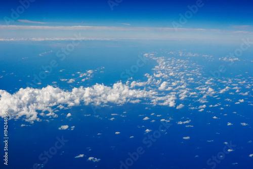 Blue sky and clouds below from airplane window © DHstudio