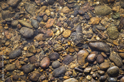 Nature concept background, Stone under clear water river at stone beach