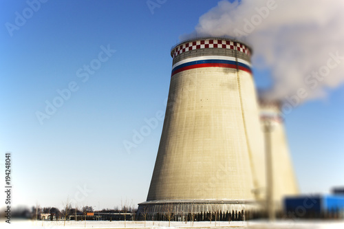 Thermoelectric power station with smoke pipe on the background of blue sky.