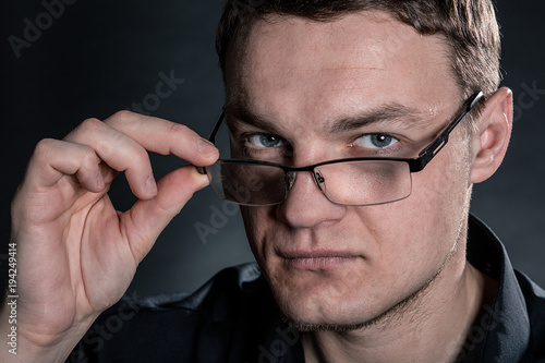 Portrait of handsome man in glasses on dark background