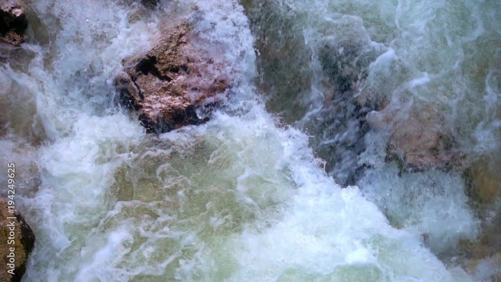 SLOW MOTION: flowing water over stones in mountines river SLOW MOTION: flowing water over stones in mountines river