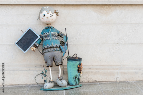 Figure of a child with a sign from the metal on the street