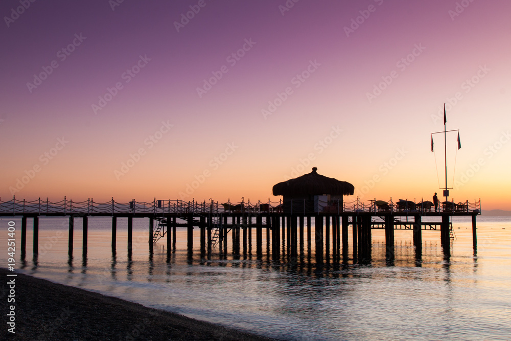 The bungalow on the pier is flooded with sunlight. Lilac from the dawn sky. The bungalow on the pier is flooded with sunlight. Lilac from the dawn sky.