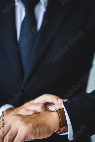 Businessman looking at his watch in office