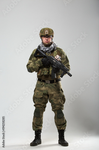 Full-length photo of soldier with gun in his hand