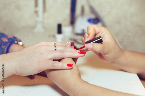 Woman doing manicure in beauty salon.