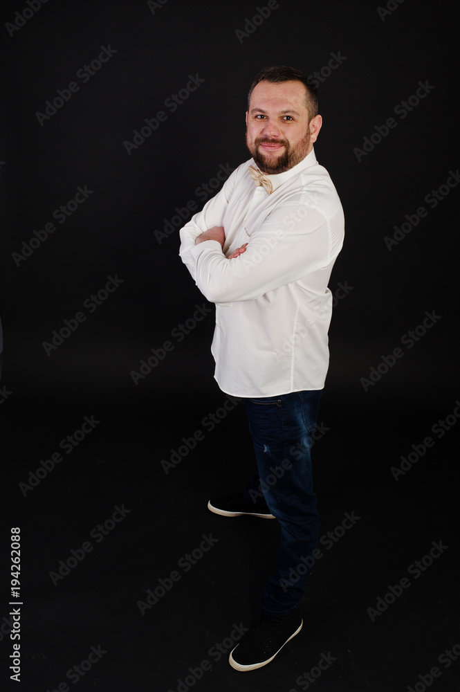 Stylish beard man in shirt with bow tie posed on studio isolated on black. Stylish beard man in shirt with bow tie posed on studio isolated on black.