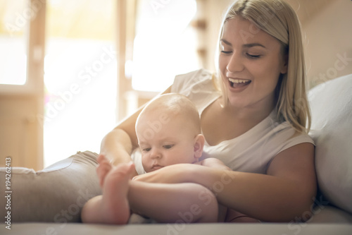 Smiley happy mother with baby boy at home.