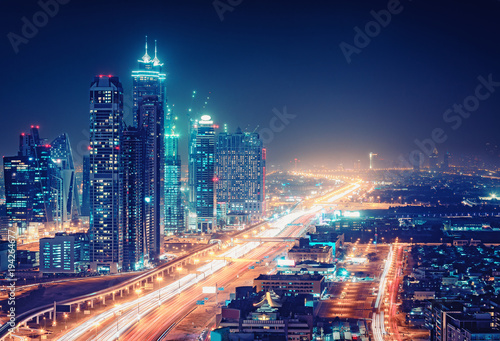 Spectacular nighttime skyline of a big modern city at night.. Dubai, UAE. Aerial view on highways and skyscrapers.