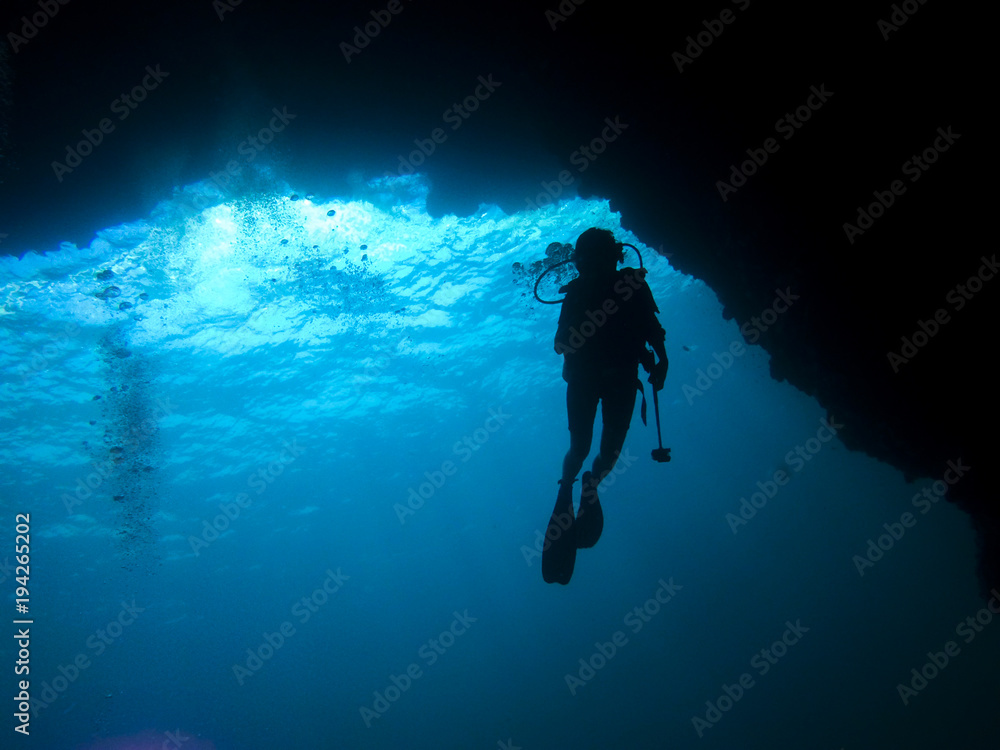 silhouette diver in a cave silhouette diver in a cave