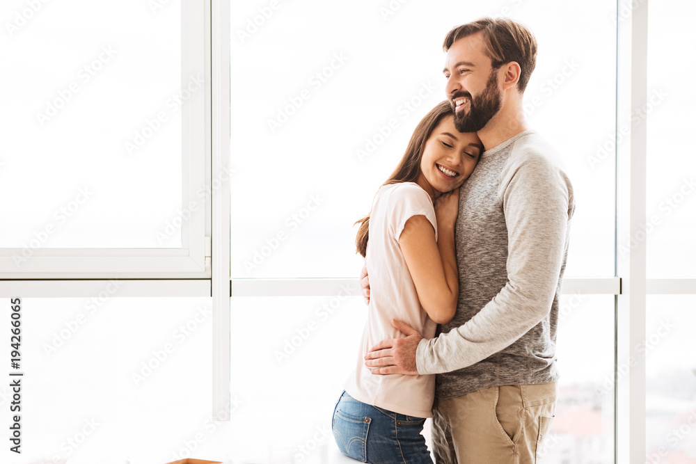 Naklejka premium Smiling young couple embracing while standing