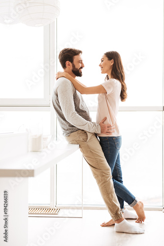 Lovely young couple embracing while standing together