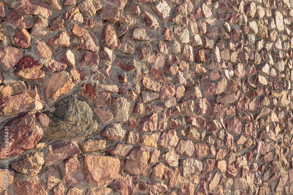 masonry of the old wall of rough cut red stone