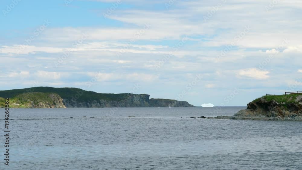 Slow motion white ice berg floating by town of twillingate Newfoundland Slow motion white ice berg floating by town of twillingate Newfoundland