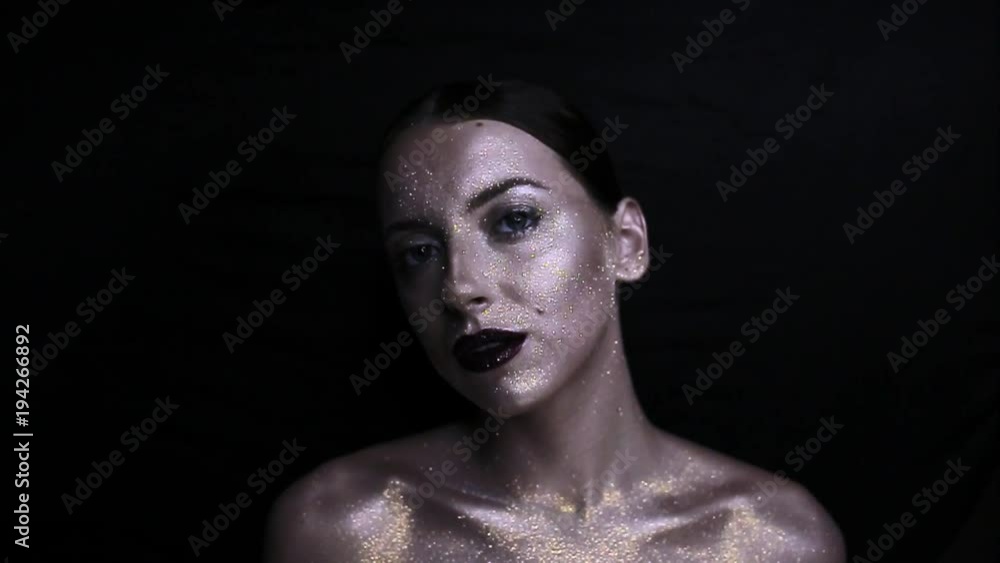 The girl's face is covered with gloss and glitter . Posing The girl's face is covered with gloss and glitter . Posing