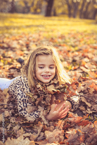 Happy little girls on fallen leaves.