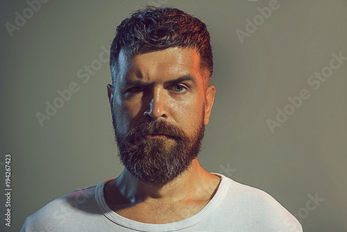 Portrait of bearded man face with stylish hairstyle in white shirt. Confidence and success. Sexy male model, serious face, fashionable hairstyle Athletic bearded man. Solid man with beard and mustache