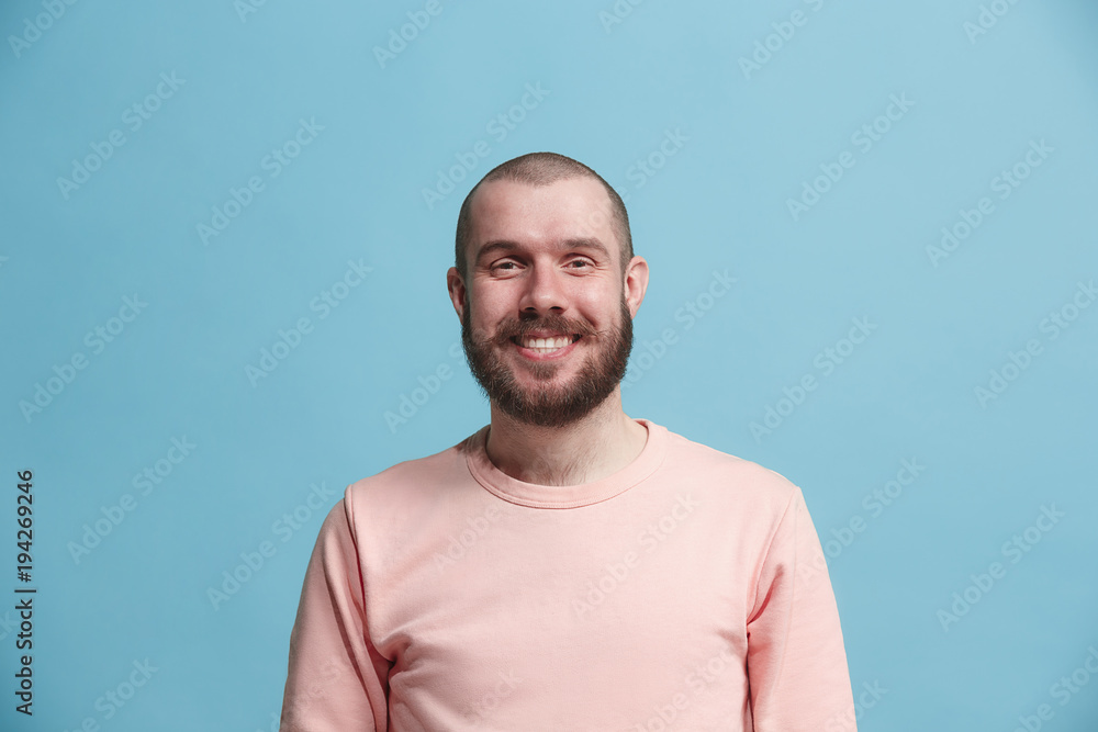 The happy business man standing and smiling against blue background. The happy business man standing and smiling against blue background.