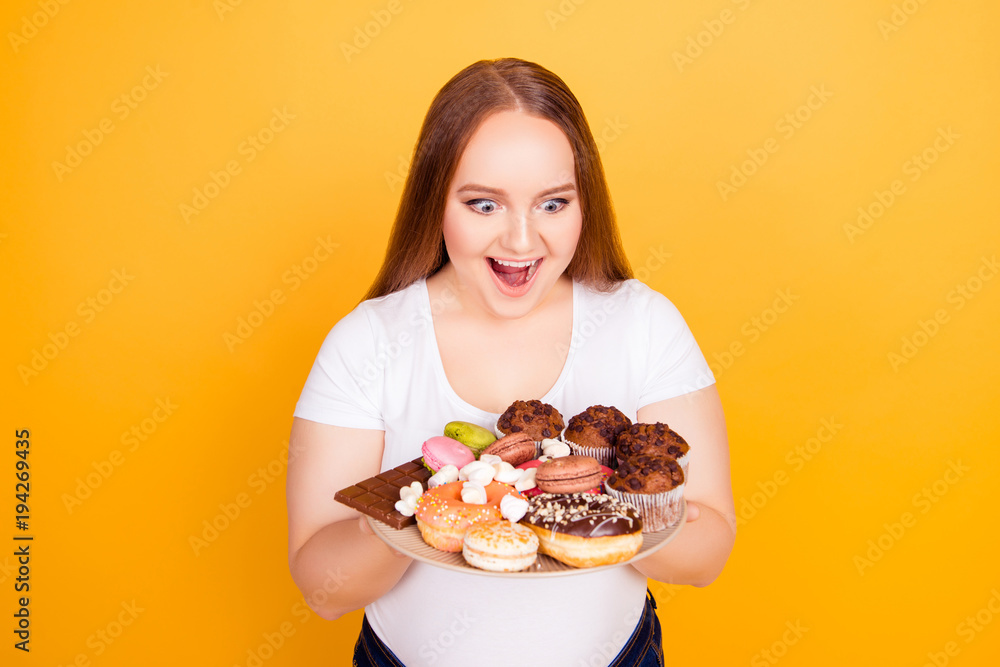 Happy young woman holds plate of pastries Happy young woman holds plate of pastries