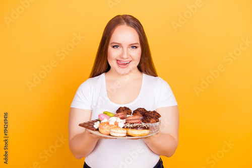 Young woman holds plate of pastries and donuts