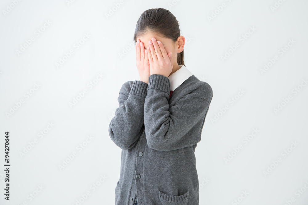 顔を隠す女子学生 顔を隠す女子学生