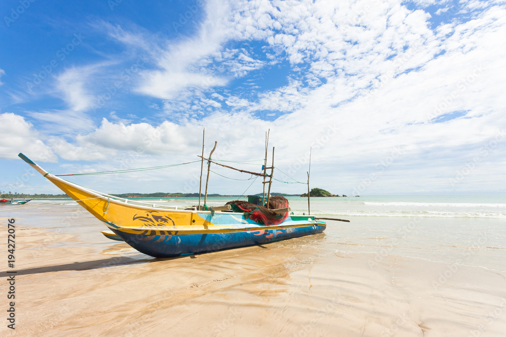 Weligama Beach, Sri Lanka - A traditional fishing boat at the sandy beach of Weligama