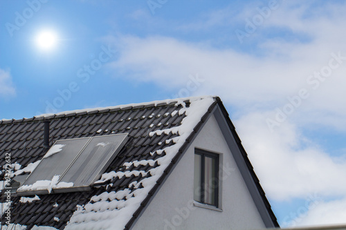 house with solar panels on the roof and blue sky in winter © OFC Pictures