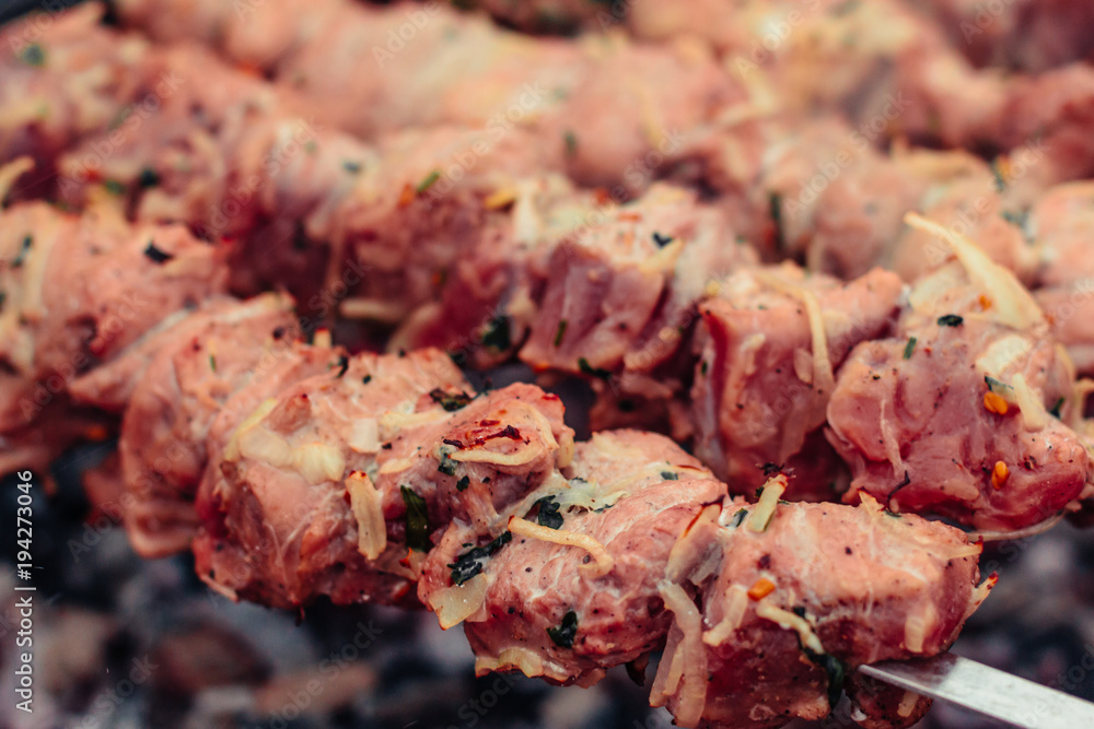 Tasty grilled meat on metal skewers on the brazier in winter. Roasted meat cooked at barbecue. BBQ fresh beef meat chop slices. Traditional eastern dish, shish kebab. Tasty grilled meat on metal skewers on the brazier in winter. Roasted meat cooked at barbecue. BBQ fresh beef meat chop slices. Traditional eastern dish, shish kebab.