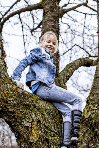 young beautiful girl is climbing on tree